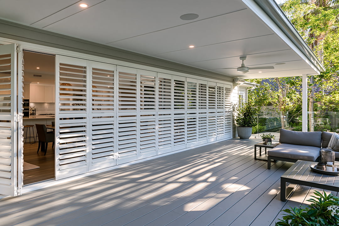 White bi-fold aluminium shutters on an alfresco deck