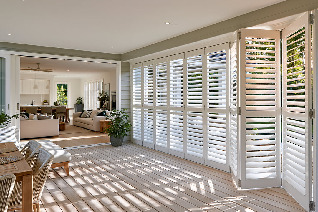 White bi-fold aluminium shutters in an alfresco living area